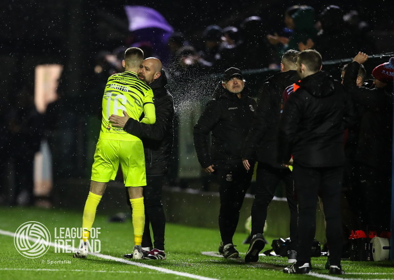21 March 2025; Cobh Ramblers goalkeeper Timothy Martin celebrates his sides second goal with goalkeeping coach Noel Cantwell during the SSE Airtricity Men's First Division match between Cobh Ramblers and Athlone Town at St Colman's Park in Cobh, Cork. Photo by Michael P Ryan/Sportsfile